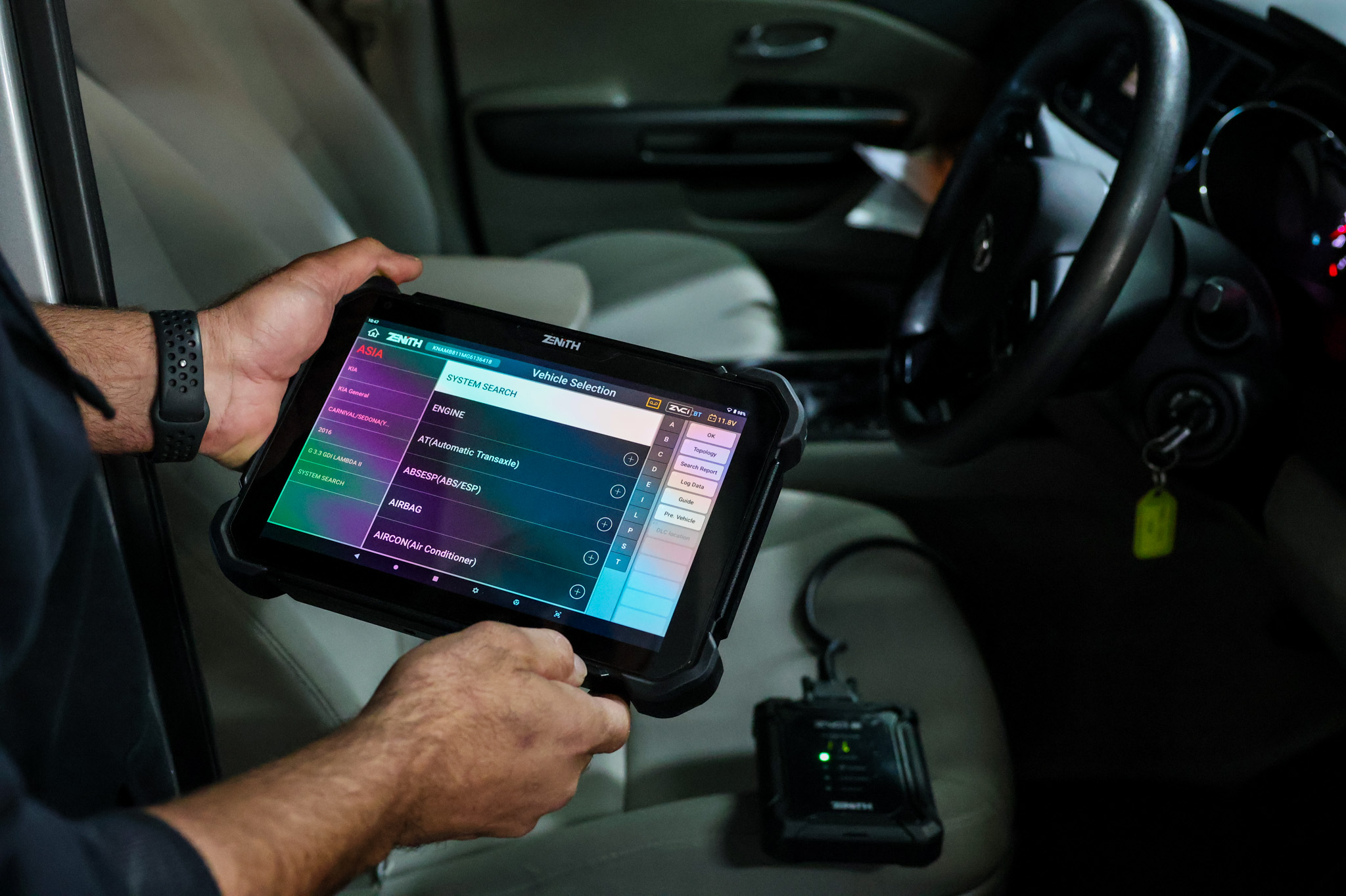 auto electrician diagnosing fault Auto electrician using a diagnostic scan tool to identify vehicle electrical faults in Brisbane.